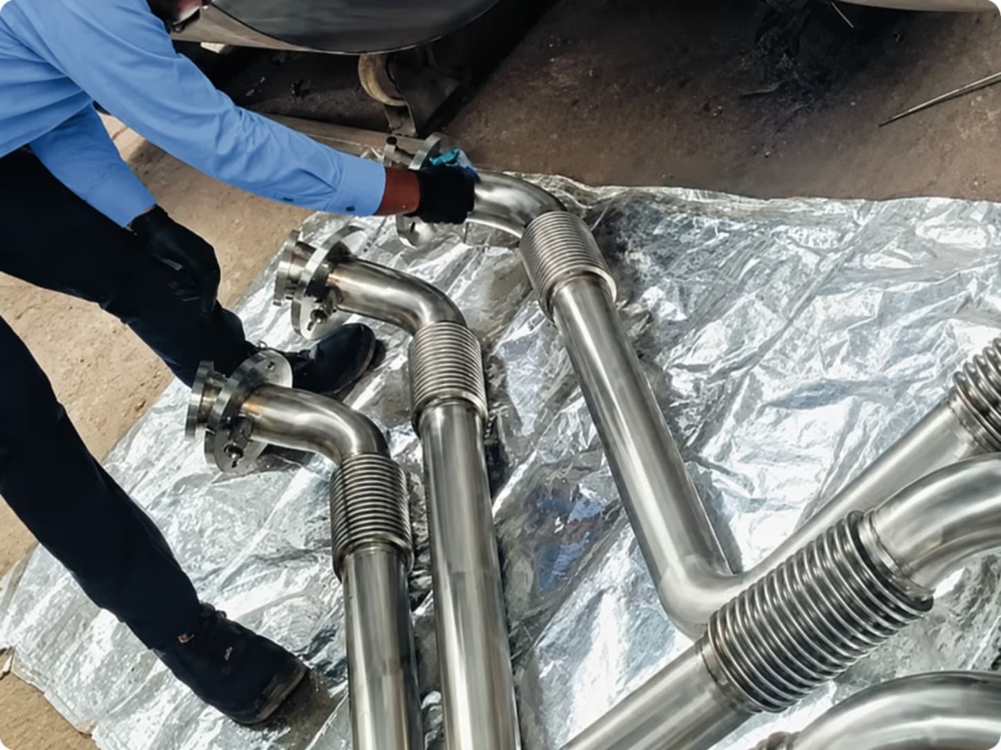 A Fluid Controls technician fitting bellows-and-tube piping assemblies on site